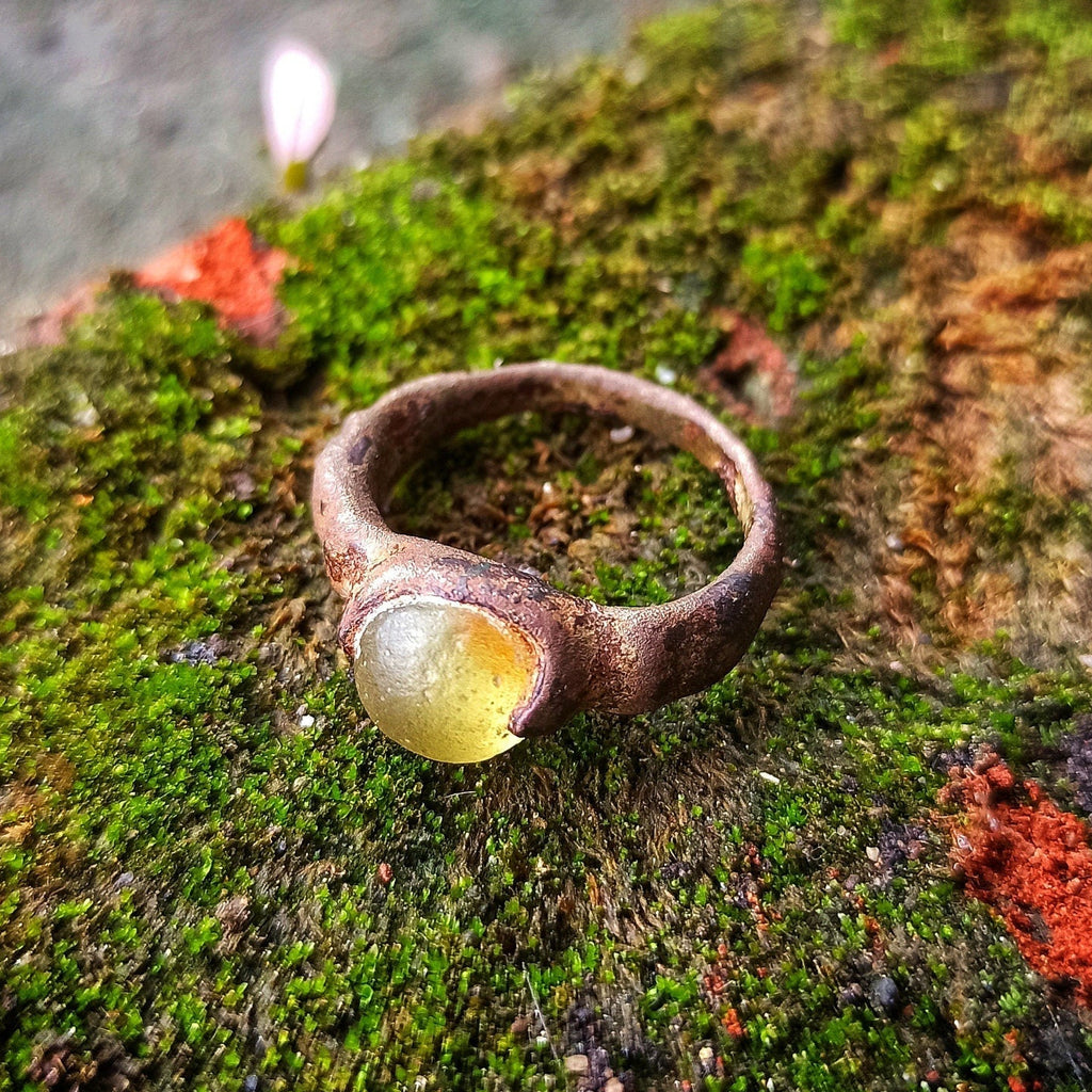 Ring with a stone on a mossy surface